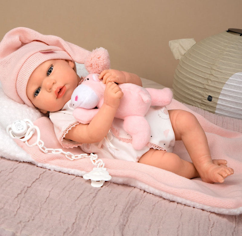 Bebé Reborn Ariel rosa con cojín y peluche